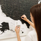 Woman marking locations on a map with pins