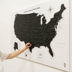 Map of the United States with a hand scratching off a location on a white background