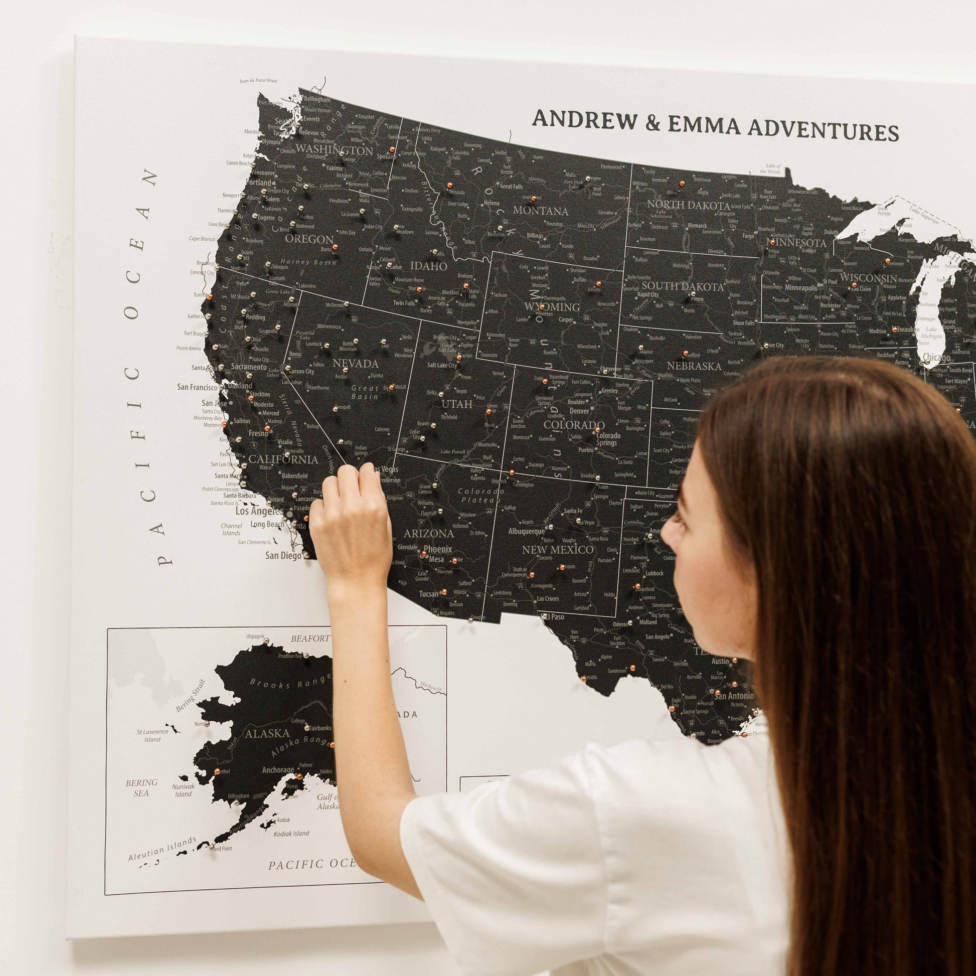 Woman looking at a large map of the United States with 'Andrew & Emma Adventures' text.