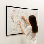 Woman interacting with a map on a wall, using a small object.