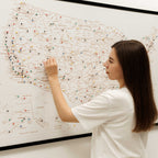 Woman interacting with a map of the United States on a wall.