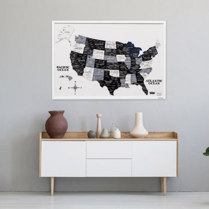 Framed map of the United States on a wall above a white cabinet with wooden accents.
