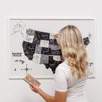 Woman interacting with a map of the United States on a wall, holding a remote control.