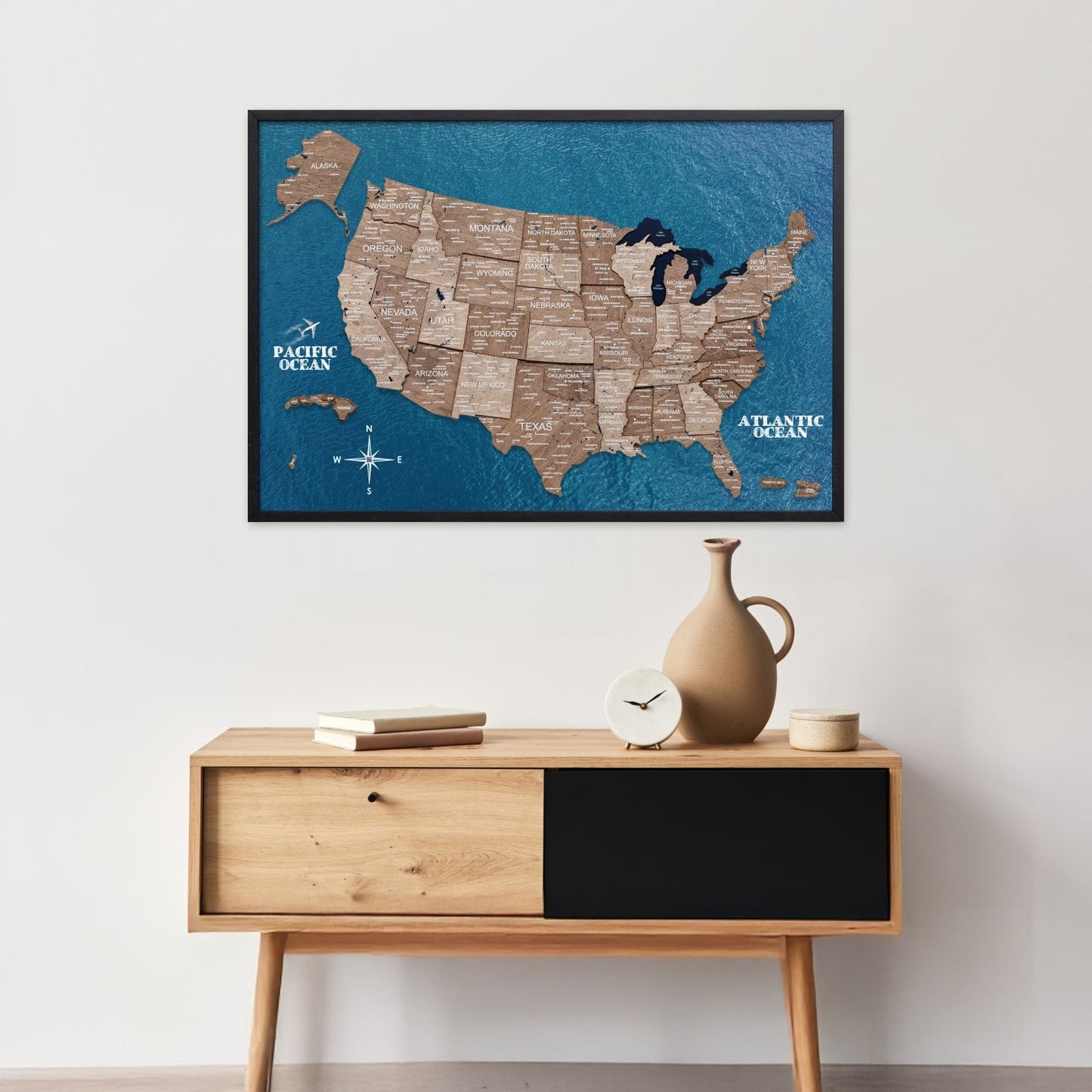 Framed map of the United States on a wall above a wooden console table.