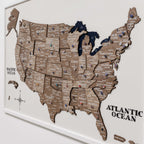 Wooden map of the United States with pins on a white background