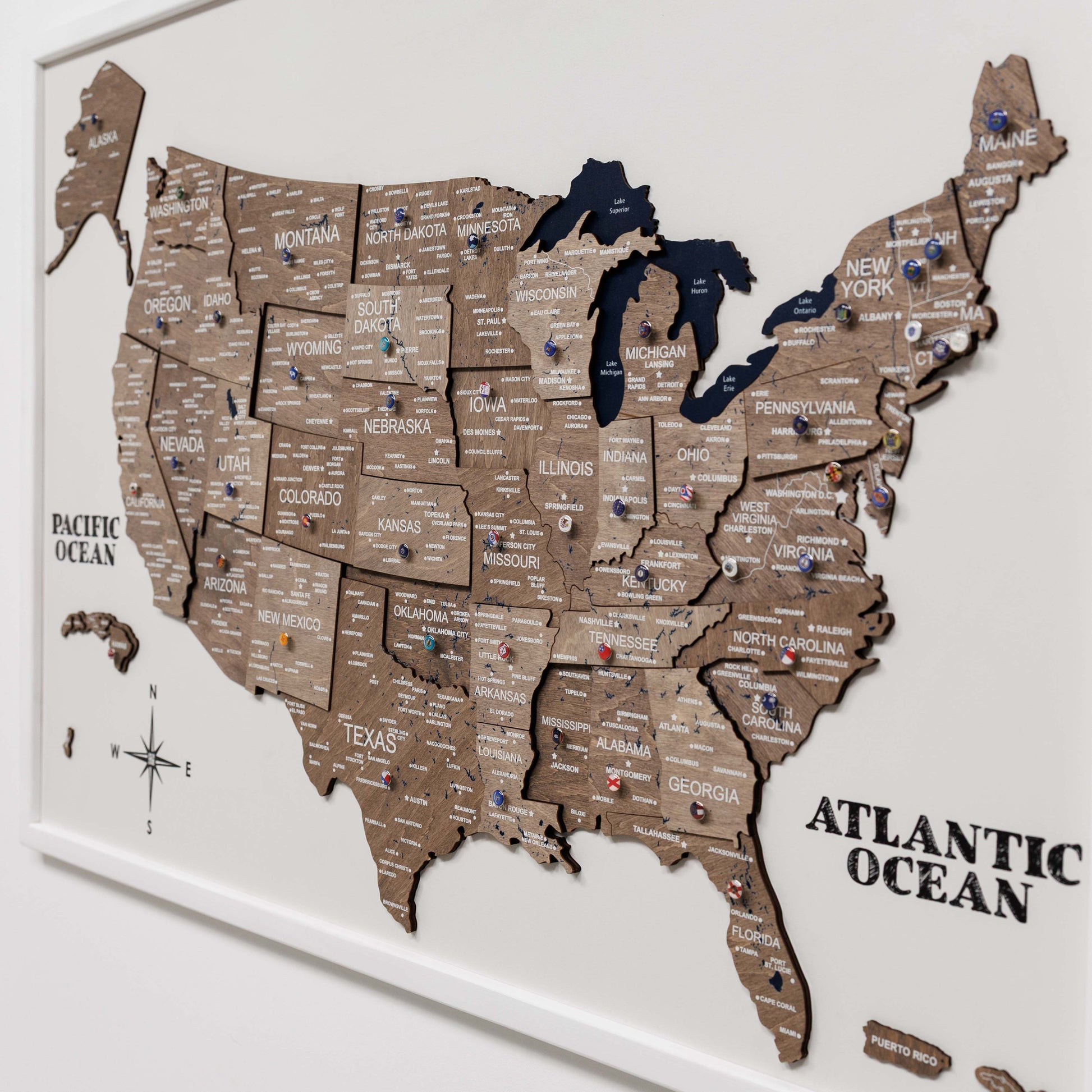 Wooden map of the United States with pins on a white background