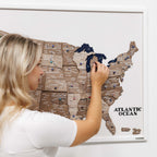Woman interacting with a magnetic USA map on a white wall