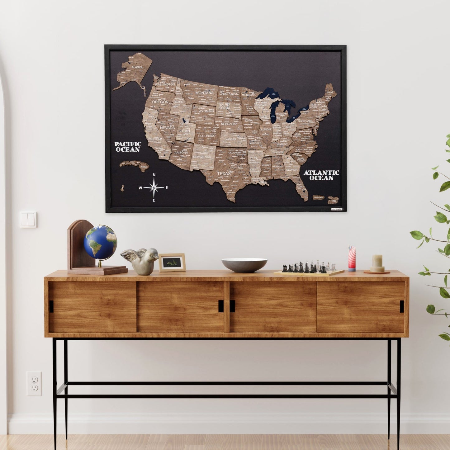 Wooden console table with decorative items and a framed map of the United States on the wall.