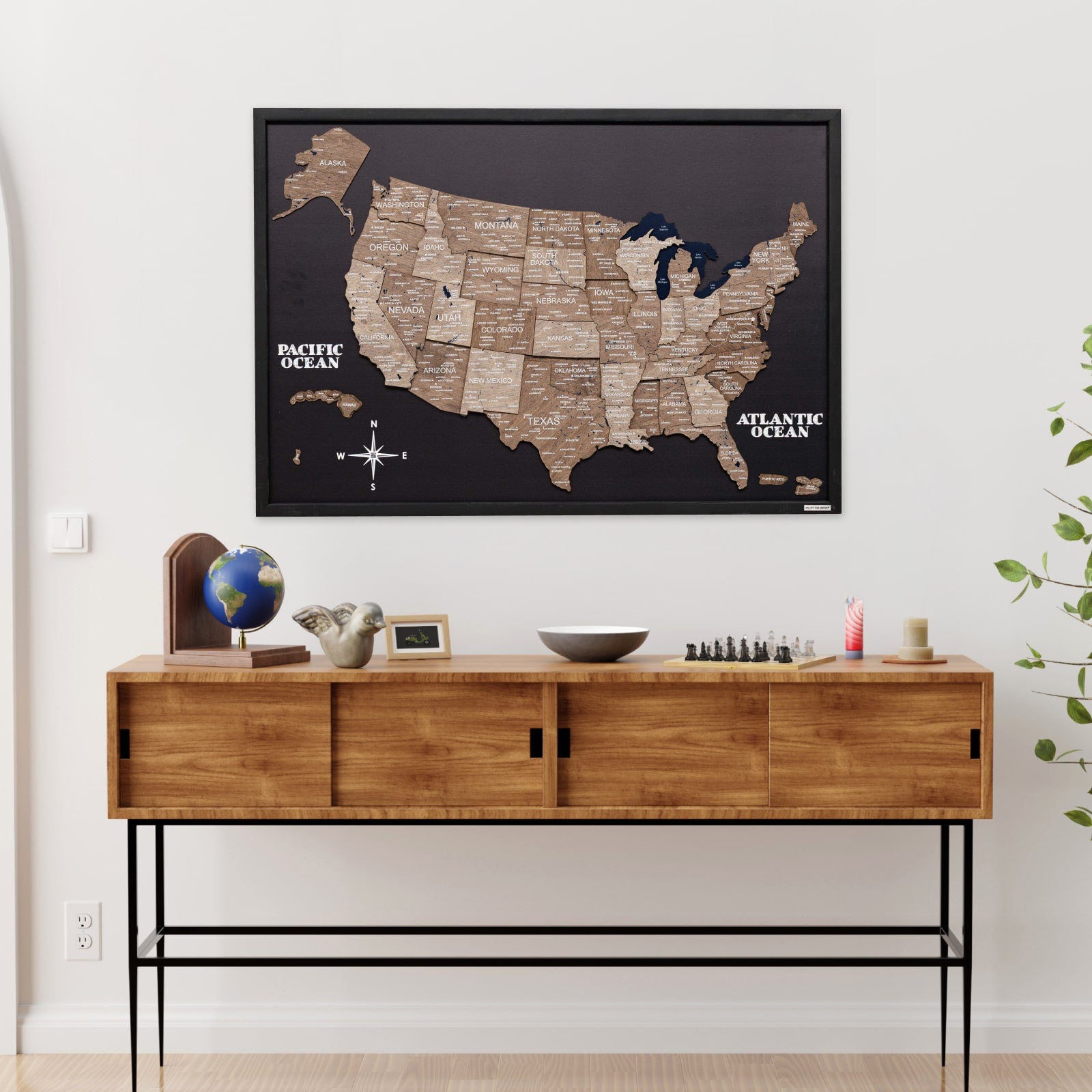 Wooden console table with decorative items and a framed map of the United States on the wall.