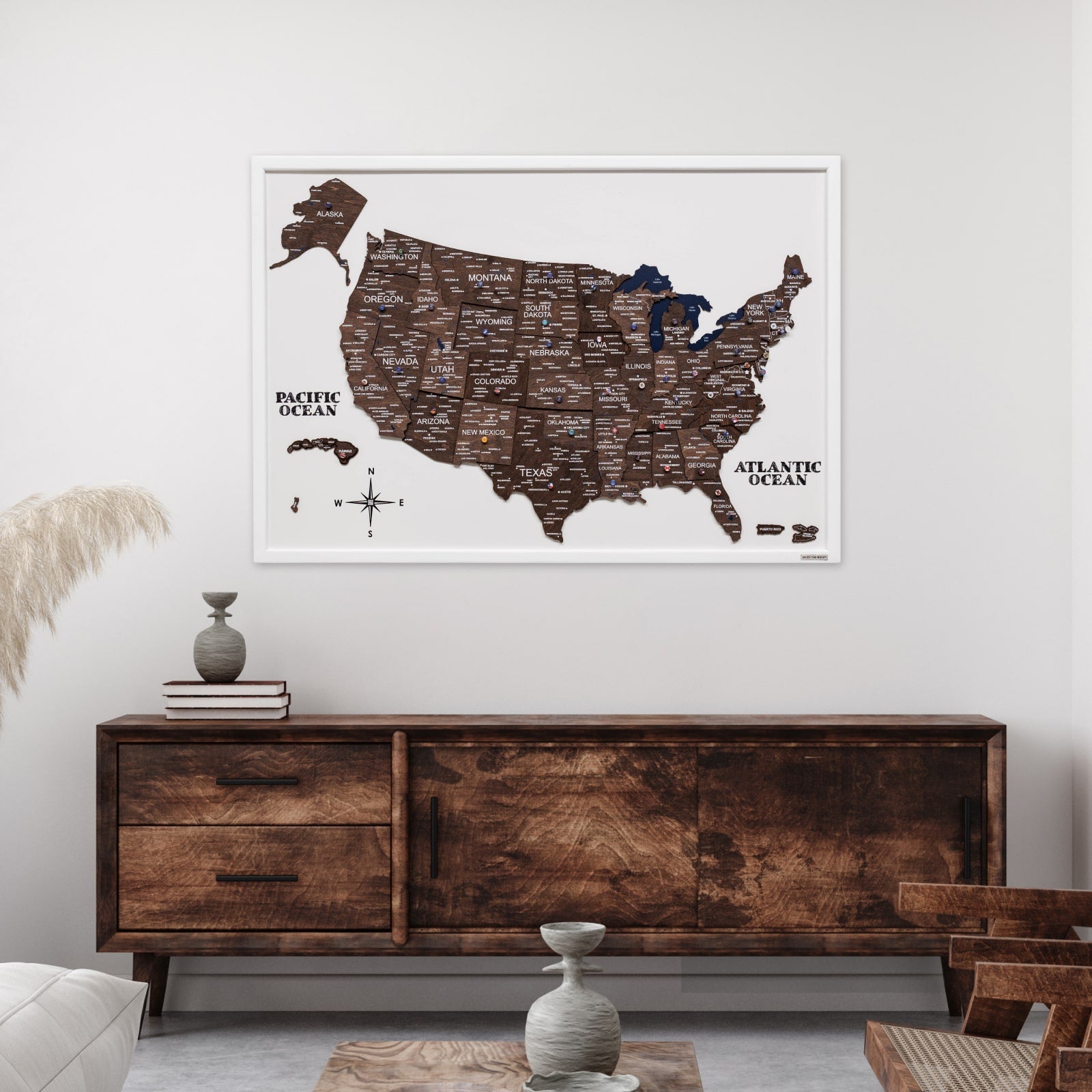 Framed map of the United States on a wall above a wooden sideboard.