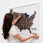 Woman interacting with a magnetic USA map on a white wall