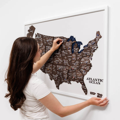Woman interacting with a magnetic USA map on a white wall