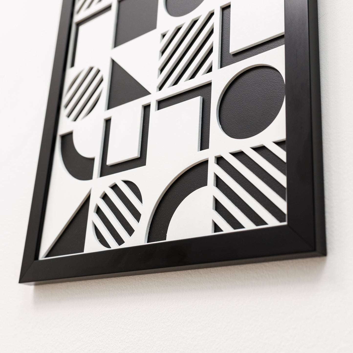 Framed black and white geometric art piece on a light background