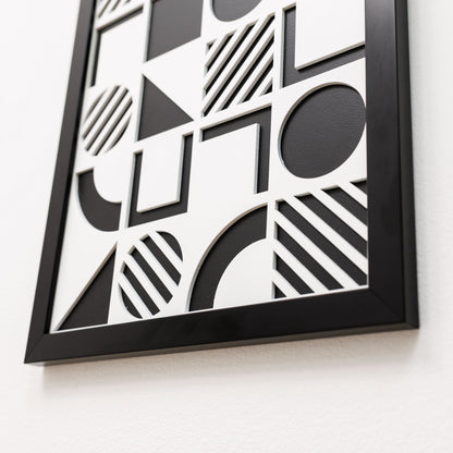 Framed black and white geometric art piece on a light background