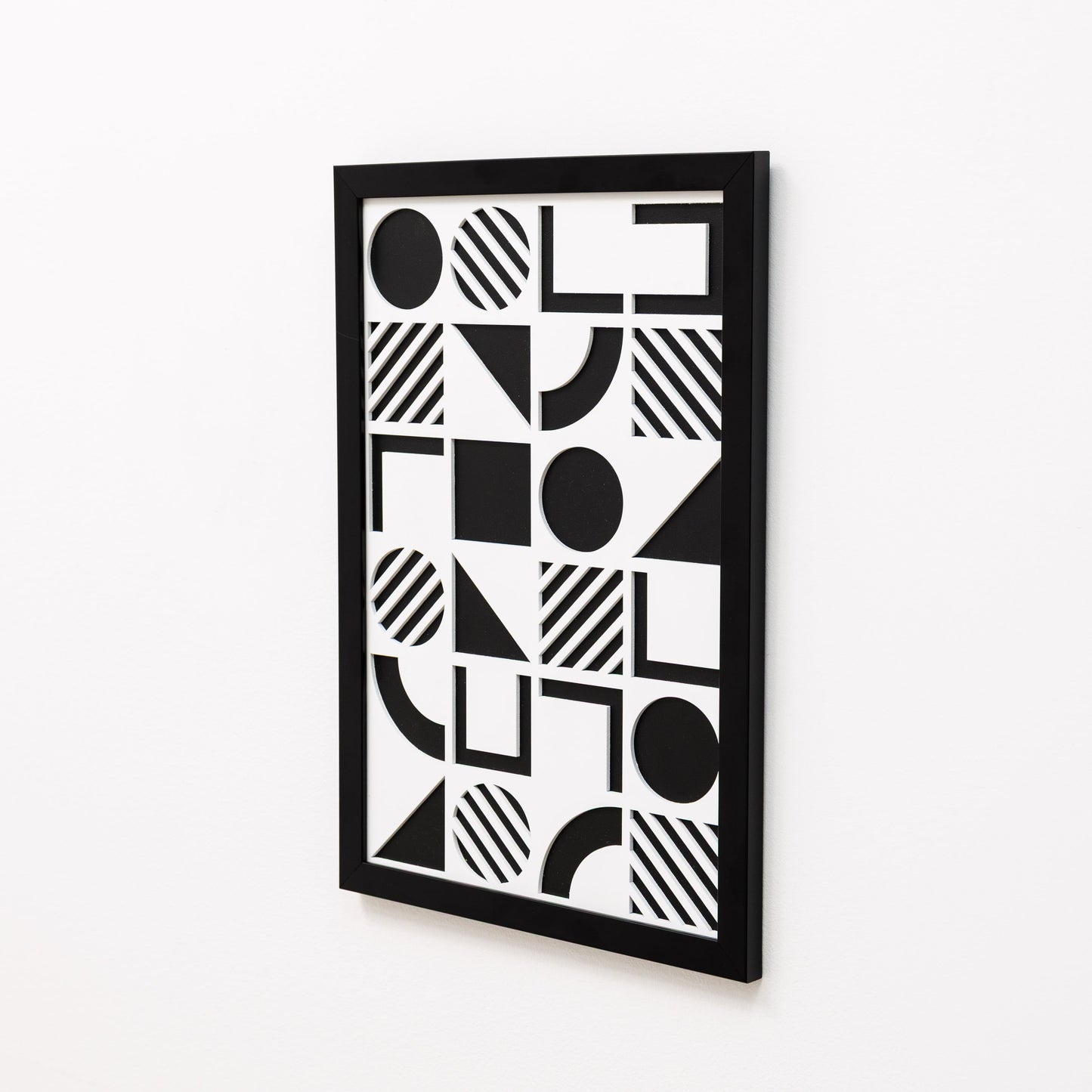 Black and white geometric patterned wall art on a white background