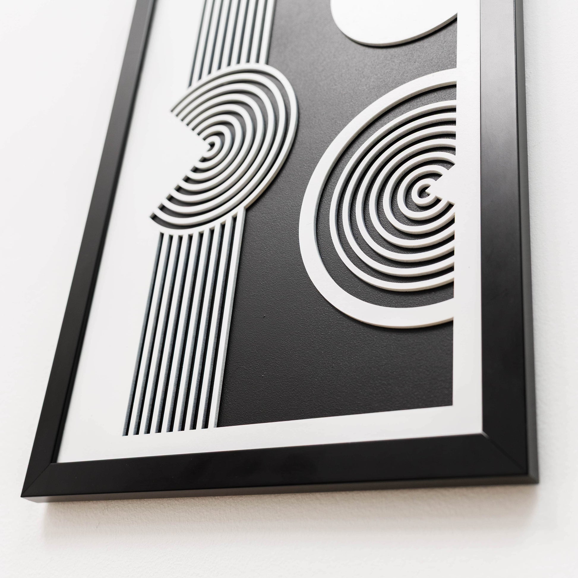 Framed black and white abstract art piece on a white background