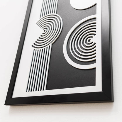 Framed black and white abstract art piece on a white background