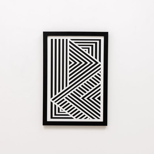 Framed black and white geometric art print on a white wall