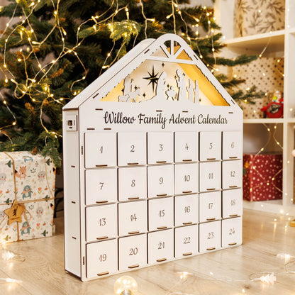 White advent calendar with 'Willow Family' branding in front of a decorated Christmas tree.