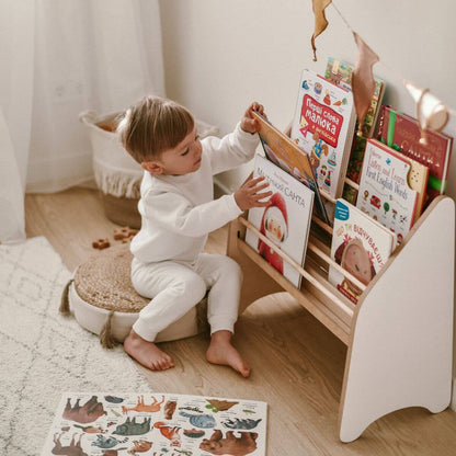 Child exploring colorful storybooks in reading corner