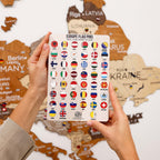 Packaging of Europe flag pins held in front of a wooden map of Europe.
